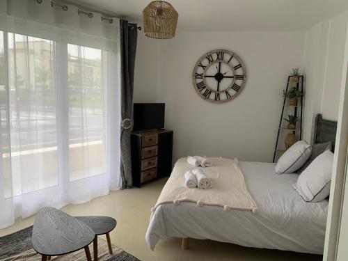 um quarto com uma cama e um relógio na parede em La colline aux oiseaux em Caen
