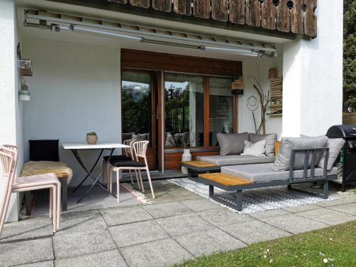 a patio with a couch and a table and chairs at Abitaziun Patgific in Trin