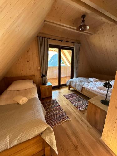 a attic bedroom with two beds and a window at Bieszczadzka Dziupla in Cisna