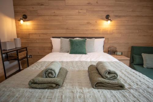 a bedroom with a large bed with towels on it at Emerald nest Eastbourne in Eastbourne