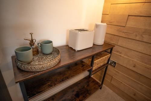 una mesa con dos tazas y una tostadora en ella en Emerald nest Eastbourne, en Eastbourne