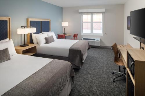 a hotel room with two beds and a flat screen tv at Hotel Ursa in Orono
