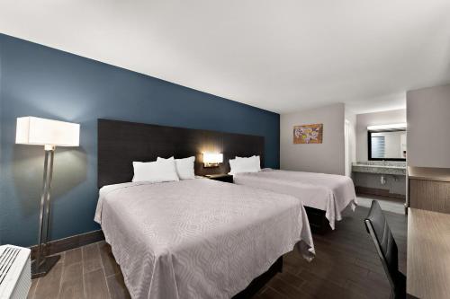 Habitación de hotel con 2 camas y pared azul en Econo Lodge Inn & Suites, en Laredo