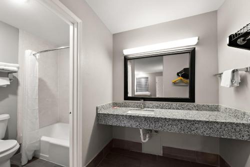 Econo Lodge Inn & Suites في لاريدو: حمام مع حوض ومرآة