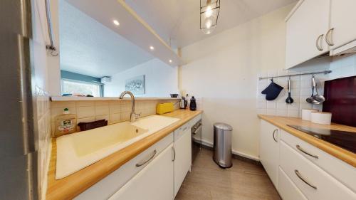 uma cozinha com um lavatório e uma grande banheira em Marina vue mer em Le Grau-du-Roi