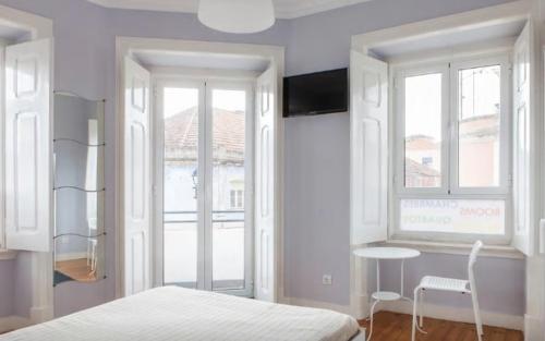 a white bedroom with a bed and a window at Suites & Apartments DP VFXira in Vila Franca de Xira