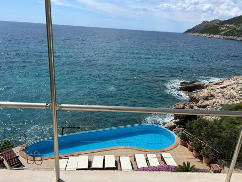 a blue bench on a balcony overlooking the ocean at Resort Stikovic in Dobra Voda