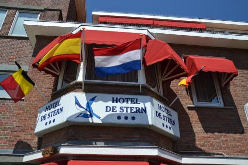 un panneau d'hôtel avec drapeaux sur le côté d'un bâtiment dans l'établissement Hotel De Stern, à Scheveningen