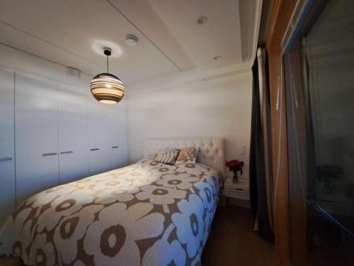 1 dormitorio con 1 cama con edredón marrón y blanco en Luksuskolmio järvinäköalalla, en Jyväskylä