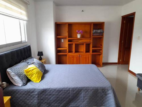 een slaapkamer met een bed met een geel kussen erop bij Apartamento Hermoso Riosucio 201 in Ruiosucio