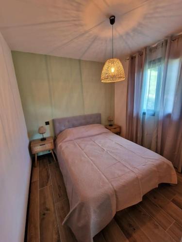 une chambre avec un grand lit et un lustre dans l'établissement Belle villa à la campagne dans un coin cosy, à Sartène
