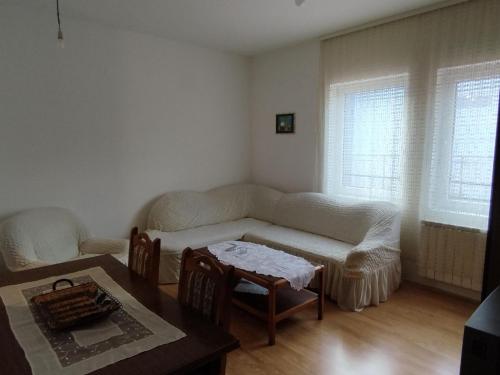 een woonkamer met een bank en een tafel bij MR Apartman in Belgrado