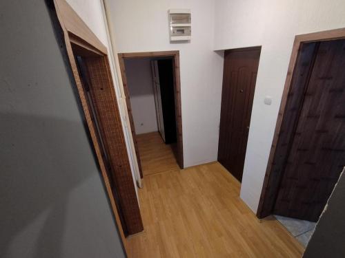 een lege hal met twee deuren en houten vloeren bij MR Apartman in Belgrado