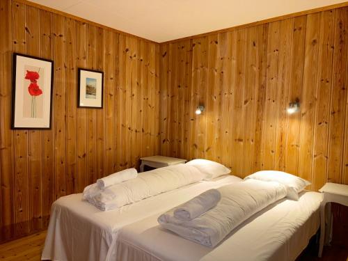 two beds in a room with wooden walls at Brekke Apartments in Flåm