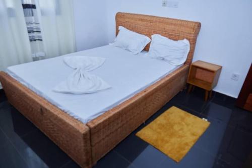 a bedroom with a bed with a wicker bed frame at Akouma immo in Emana