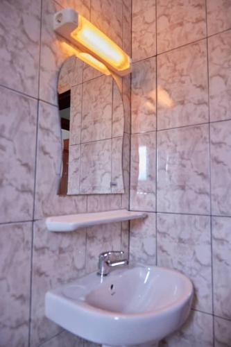 W łazience znajduje się umywalka i lustro. w obiekcie Akouma immo w mieście Emana