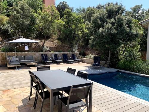 - une table à manger et des chaises à côté de la piscine dans l'établissement VILLA MYRTE A CIRINDINU, à Cirendinu