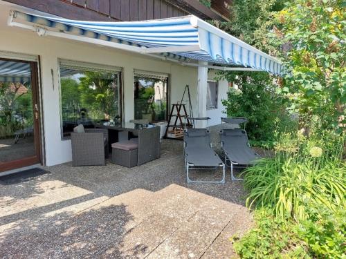 a patio with chairs and a table and an umbrella at Hibiskus - a83456 in Leutkirch im Allgäu