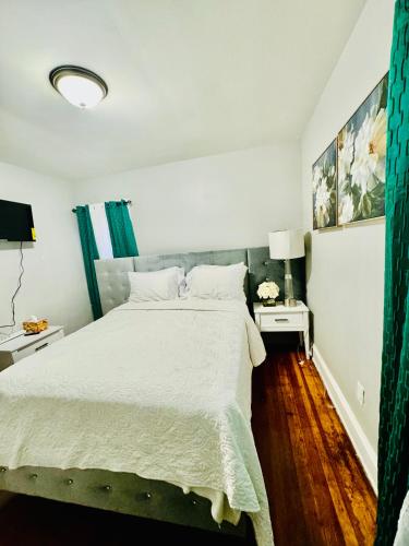 um quarto com uma cama grande e lençóis brancos em Newly renovated first floor apartment getaway em Springfield