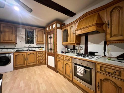 a kitchen with wooden cabinets and a stove top oven at Duchess Apartments Modern 3Bedroom Apartment in Colchester Ideal for Long Stays, Relocations, Contractors, Secure Parking, WIFI in Colchester