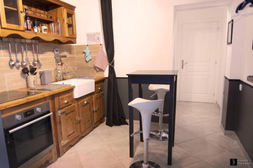 een keuken met een aanrecht en een tafel. bij Maison des Soupirs in Montpon-Ménestérol