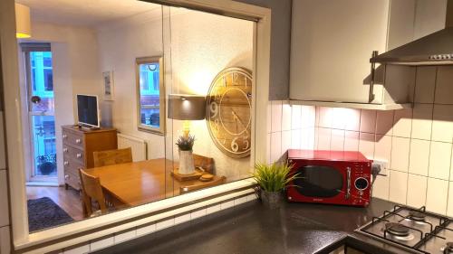 a kitchen with a table and a red microwave at Burlington Beach Apartments in Brighton & Hove