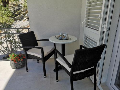 a small table and two chairs on a balcony at Apartman Sissy in Primošten