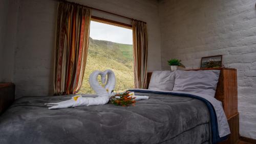 a bedroom with a bed with two swans on it at Chakana templo de montaña in Chimborazo