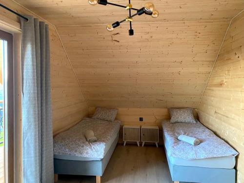 a room with two beds in a wooden cabin at Złoty Groń log houses & apartments in Istebna