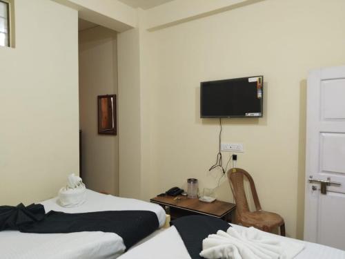 Habitación de hotel con 2 camas y TV en la pared en DAMEKI a unit of ME HOSPITALITY en Shillong