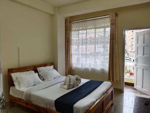 um quarto com uma cama grande e uma janela em DAMEKI a unit of ME HOSPITALITY em Shillong