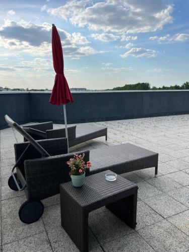 a patio with two tables and an umbrella on a roof at Hotel Apart in Warsaw