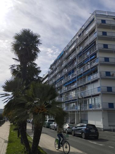 a bike parked in front of a building with palm trees at CHAMBRETTE boulevard des Pyrénées Hypercentre 10m carré WC sur le palier, porte40 in Pau