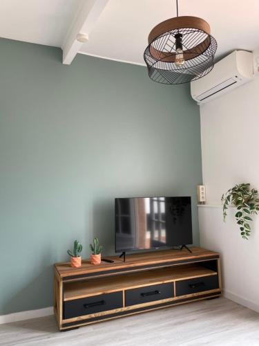 un salon avec une télévision à écran plat sur un mur dans l'établissement Villa LCSM et studio, à Frontignan