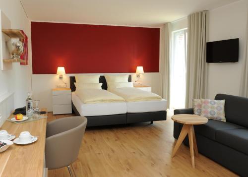 HeekにあるHotel Am Marktのベッドとソファのあるホテルの部屋