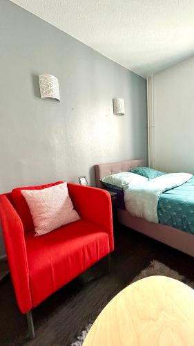 a bedroom with a red chair and a bed at Chambre Privée Kozy - Stade de France in Saint-Denis