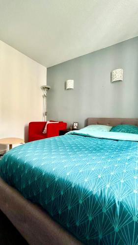 a bedroom with a bed and a red chair at Chambre Privée Kozy - Stade de France in Saint-Denis