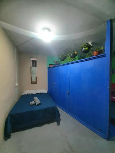 um quarto com uma cama azul e um armário azul em Huerto en el Barrio em Guadalajara