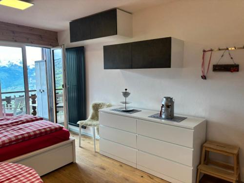 a bedroom with a bed and a dresser and a window at Studio 22 Veysonnaz in Veysonnaz
