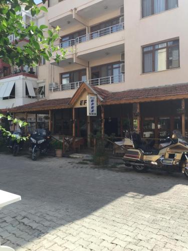a building with motorcycles parked in a parking lot at Hotel Efes in Gumuldur