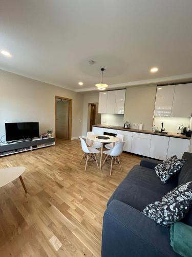 uma sala de estar com um sofá, uma mesa e uma cozinha em Pine cone cozy apartment em Riga