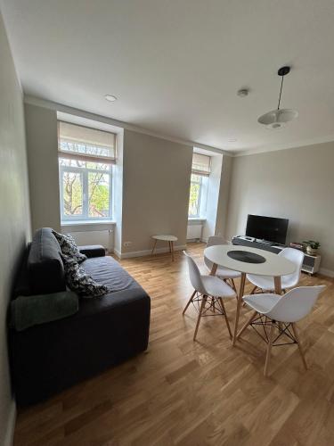 uma sala de estar com um sofá e uma mesa em Pine cone cozy apartment em Riga