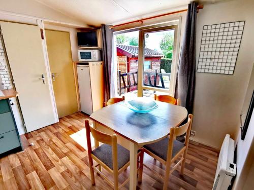 a kitchen with a table and chairs in a room at A deux pas du lac in Ardres