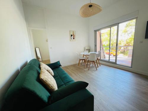 un salon avec un canapé vert et une table dans l'établissement Havre de paix cures thermales, à Dax