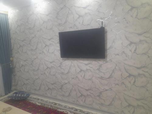 una TV a schermo piatto su un muro di pietra di Ancient Khiva Apartment 3 a Khiva