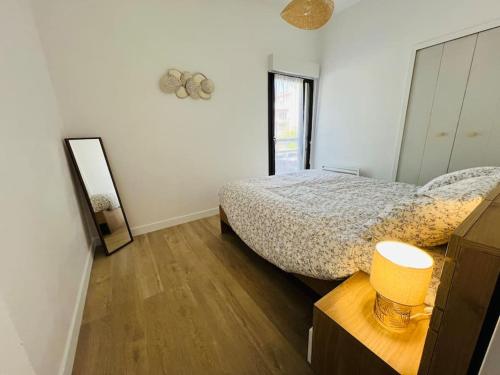 une chambre avec un lit, une commode et un miroir dans l'établissement Havre de paix cures thermales, à Dax