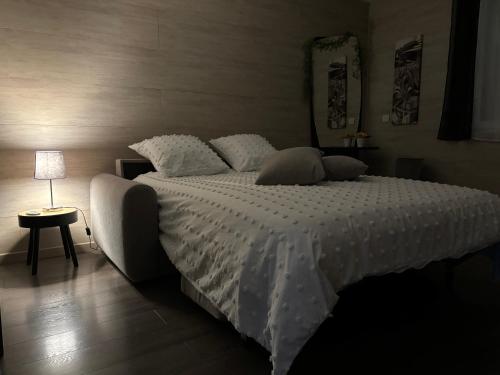 una camera da letto con un letto grande con lenzuola e cuscini bianchi di Studio 2 personnes a Vinassan