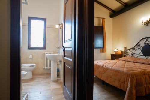 a bedroom with a bed and a sink and a toilet at Borgata Baldazza in Linguaglossa