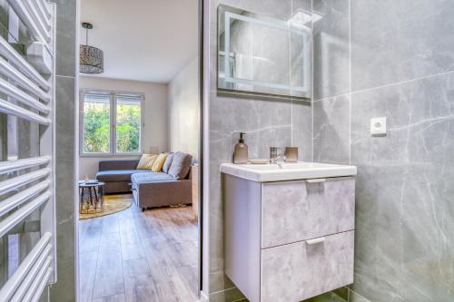 une salle de bain avec lavabo et un salon dans l'établissement Cosy Appart au rdc 4 pers 5min RER, Disney & Paris, à Villiers-sur-Marne