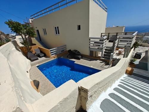 una casa con piscina al lado de un edificio en Anemomilos Villa en Firostefani